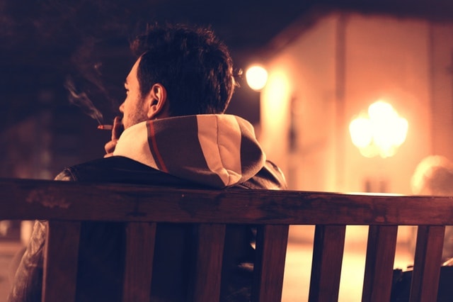 Man on Bench Smoking